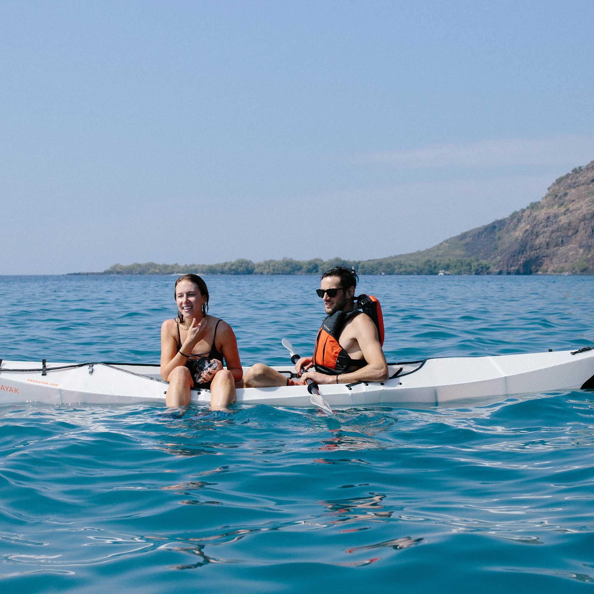 couple on a beach lt kayak on the water