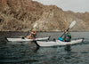Couple Kayaking on the sea surrounded by mountain