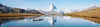 A person kayaking through the river surrounded by a lovely mountain behind