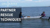 A man kayaking tries to rescue the woman on the kayak at the ocean